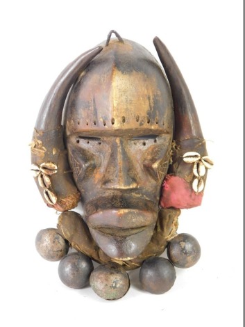 An African Tribal Dan Kran warrior's mask, with fabric border applied with shells and bells, Cote D'Ivoire circa 1940, 30cm high. Provenance: Exhibited at an International exhibition of West African Art 2023..