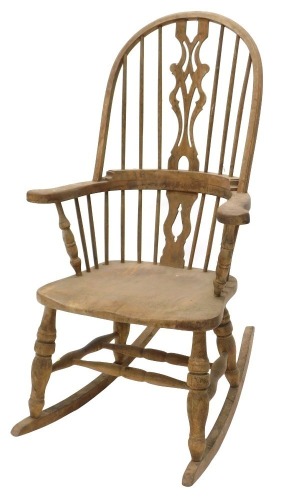 A Windsor rocking chair, with a pierced splat, solid seat, on turned legs.