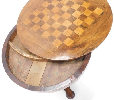 A William IV rosewood games table, the circular top inlaid with a chess board, hinged to reveal recesses for counters, gaming pieces, etc., on a concave tapering column and concave platform with bun feet, 68cm high, 56cm diameter. - 2