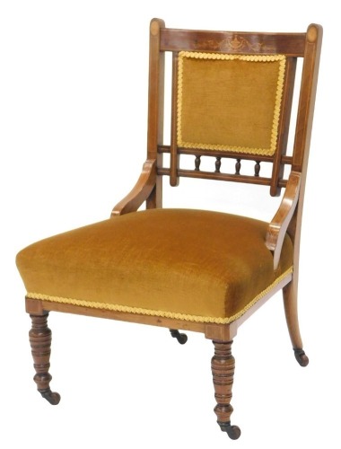 An Edwardian mahogany and marquetry nursing chair, with a padded back and seat, on turned legs with ceramic castors.