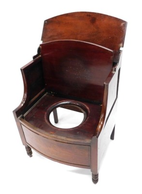 An early 19thC mahogany commode, the top with a hinged lid, with shaped arms and a further hinged section enclosing a recess for a bowl, the panelled bow front on turned legs, 60cm wide.