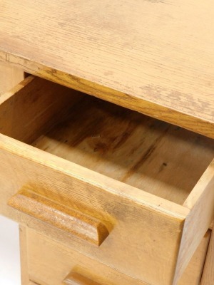 A mid 20thC oak office desk, with an arrangement of four drawers to one pedestal opposing a panel and with an unusual side tambour door, with sliding trays, each with various size divisions, 122cm wide. - 3