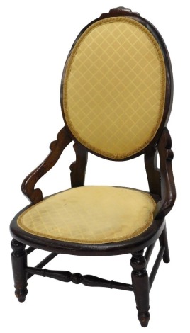 A late 19thC beech nursing chair, with a padded oval back, seat on short turned legs.