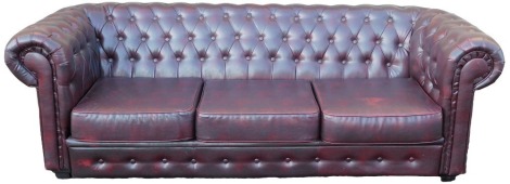 A red oxblood leather three seater Chesterfield sofa, 221cm wide.