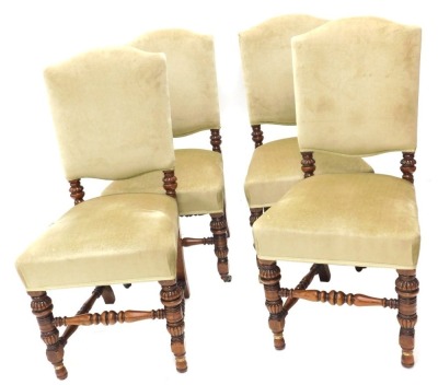 A set of four late Victorian oak dining chairs, each with a padded back and seat, on turned legs with brass castors.