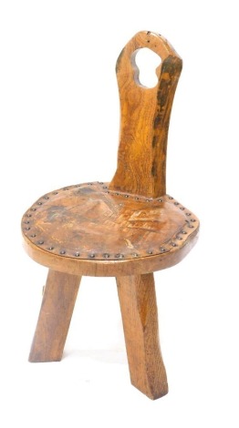 A rustic Continental elm hall chair, the leather padded seat with polychrome decoration of a town scene, on tapering legs, 35cm wide.