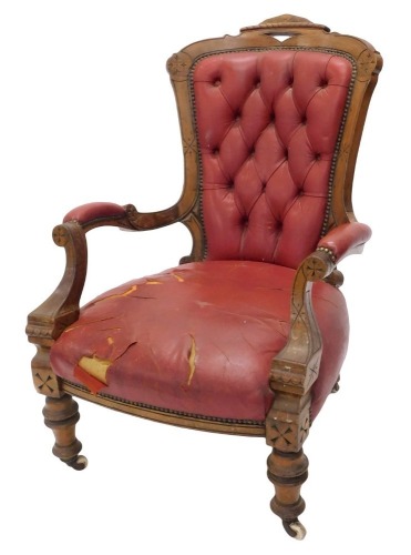 A Victorian walnut show frame chair, upholstered in red buttoned leather on turned legs with castors.