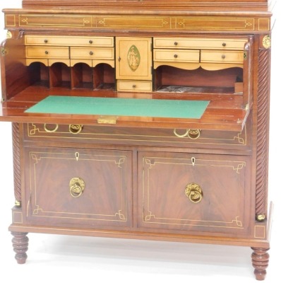 An early 19thC mahogany and brass secretaire bookcase, the top with a broken pediment above two astragal glazed doors, the base with a fall front fitted drawer enclosing fruitwood veneered interior, decorated centrally with a marquetry Britannia above a d - 2