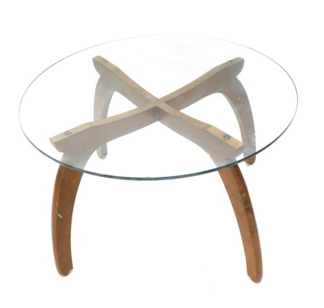 A teak coffee table, with circular glass top and X shaped base, 76cm diameter.