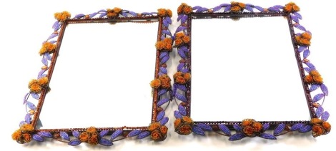 A pair of metal and multi-coloured bead work rectangular wall mirrors, each decorated with flowers and leaves, 76cm high, 48cm wide.