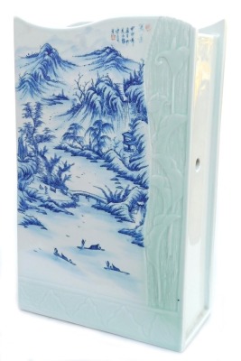 A 20thC Chinese blue and white and celadon porcelain stick stand, of rectangular section, with a wavy top and twin division interior, decorated with a river landscape, and moulded with a partial frame of leaves and lillies, signed, 43cm high, 26cm wide.