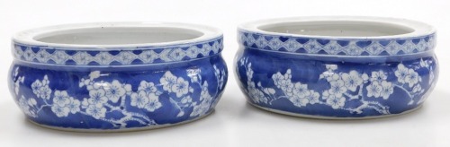 A pair of Chinese blue and white porcelain urn stands, or bowls, decorated with prunus blossom on a cracked ice ground, bears four character Wanli mark, 20cm wide.