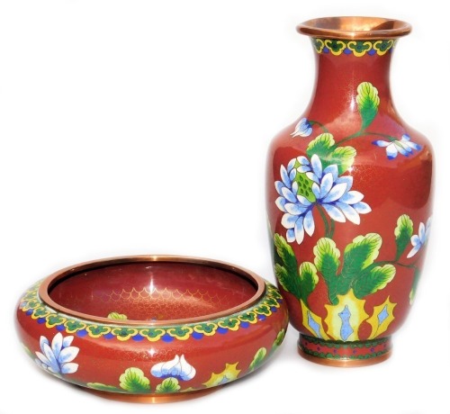 A Chinese iron red ground cloisonne enamel vase, of baluster form, decorated with blue flowers within a ground of gilt stars, 20.5cm high, and similar bowl, 16cm wide. (2)