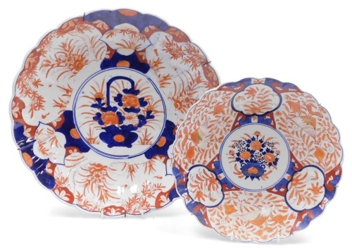 A Meiji period Japanese porcelain Imari charger, decorated centrally with a basket of flowers, within a fluted border painted with reserves of flowers and trees, 40cm wide, together with a similar dish, 30.5m wide. (2)