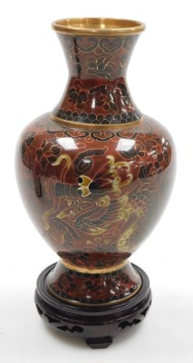 A Chinese red ground cloisonne vase, with stand, of baluster form, decorated with Imperial dragons chasing a flaming pearl, 20cm high, vase decorated with flowers on a black ground, 15.5cm high, and a vase decorated with peacocks on a blue ground, 15.5cm - 2