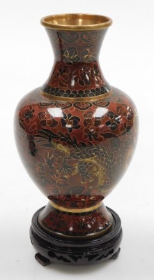 A Chinese red ground cloisonne vase, with stand, of baluster form, decorated with Imperial dragons chasing a flaming pearl, 20cm high, vase decorated with flowers on a black ground, 15.5cm high, and a vase decorated with peacocks on a blue ground, 15.5cm - 4