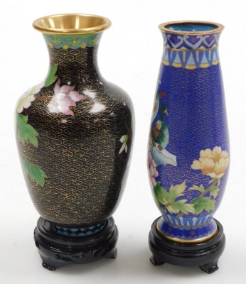 A Chinese red ground cloisonne vase, with stand, of baluster form, decorated with Imperial dragons chasing a flaming pearl, 20cm high, vase decorated with flowers on a black ground, 15.5cm high, and a vase decorated with peacocks on a blue ground, 15.5cm - 11