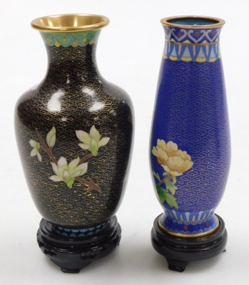 A Chinese red ground cloisonne vase, with stand, of baluster form, decorated with Imperial dragons chasing a flaming pearl, 20cm high, vase decorated with flowers on a black ground, 15.5cm high, and a vase decorated with peacocks on a blue ground, 15.5cm - 12