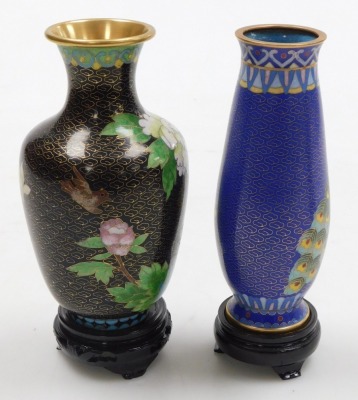 A Chinese red ground cloisonne vase, with stand, of baluster form, decorated with Imperial dragons chasing a flaming pearl, 20cm high, vase decorated with flowers on a black ground, 15.5cm high, and a vase decorated with peacocks on a blue ground, 15.5cm - 13