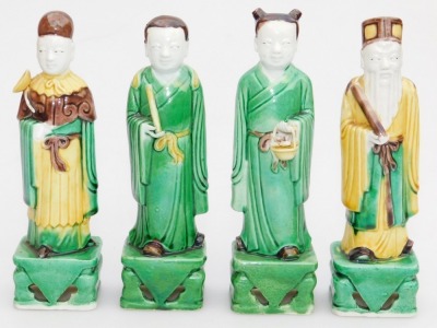 Five Qing dynasty sancai glazed figures, of a seated Buddha, 11cm high, and standing court officials on rectangular bases, 14.5cm high, - 5