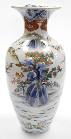 A Japanese Meiji period Arita vase, of shouldered, ovoid form, decorated with a river and mountain landscape, with pagodas, boats, cranes and figures, 56cm high.