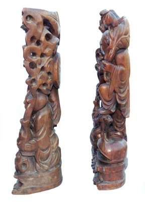 A late 19thC Chinese hardwood carving of a Buddha, seated on a lotus flower, 33cm high, and a pair of carvings of two women bat catchers, one seated, the other standing upon a shell, within a surround of bats and clouds, 38cm high. (3, AF) - 10