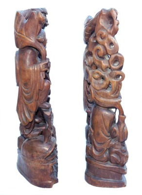 A late 19thC Chinese hardwood carving of a Buddha, seated on a lotus flower, 33cm high, and a pair of carvings of two women bat catchers, one seated, the other standing upon a shell, within a surround of bats and clouds, 38cm high. (3, AF) - 12