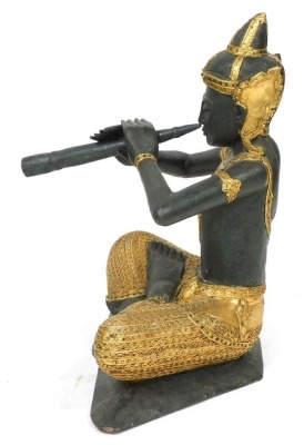 A Thai wooden and gilded carving of Prince Phra Aphai Mani, modelled seated playing his flute, with mirrored detailing, 70cm high. - 2