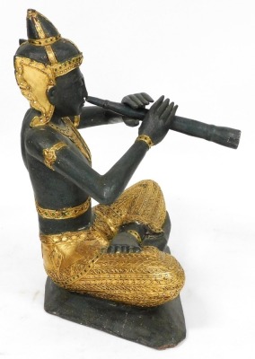 A Thai wooden and gilded carving of Prince Phra Aphai Mani, modelled seated playing his flute, with mirrored detailing, 70cm high. - 4