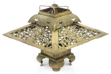 A Meiji period Japanese brass lantern, of compressed, square form, with pierced and engraved floral decoration, raised on four scroll feet, 34cm high, 42.5cm wide.