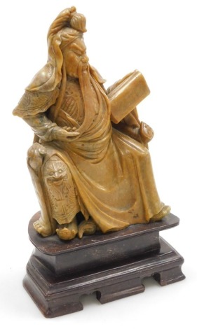 A Chinese soapstone figure of Guan Yu, Chinese god of wealth, modelled seated on a throne, with a scroll, raised on plinth base, 31cm high.