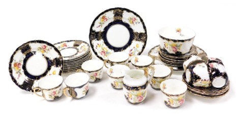 A late 19thC porcelain tea service, decorated with reserves of flowers against a cobalt blue ground, gilt heightened, comprising a pair of bread plates, a cream jug, sugar bowl, twelve cups, saucers and plates.