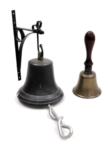 A brass school bell, with a turned wooden handle, 25cm high, together with an Italian bell, on a cast iron bracket. (2)