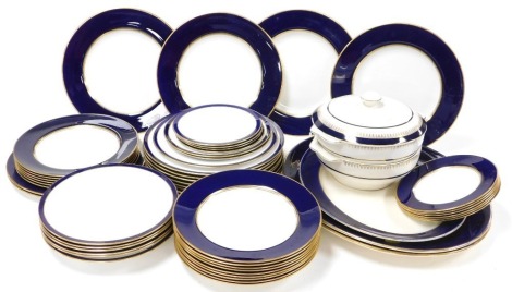 An early 20thC Wedgwood and Spode composite dinner service, decorated with cobalt blue and gilt banding, printed marks, comprising; fifteen dinner, 12 dessert and soup plates, and ten side plates, together with three matched pottery meat platters, pair of