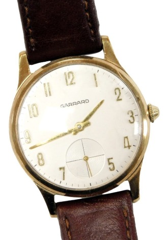 A Garrard 9ct gold cased gentleman's wristwatch, circular silvered dial bearing Arabic numerals, subsidiary seconds dial, clockwork movement, the case presentation engraved, on a leather strap.