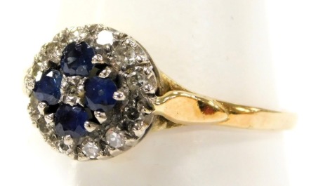 An 18ct gold sapphire and diamond flowerhead ring, claw set with four sapphires in a surround of twelve diamonds, size S, 3.3g.