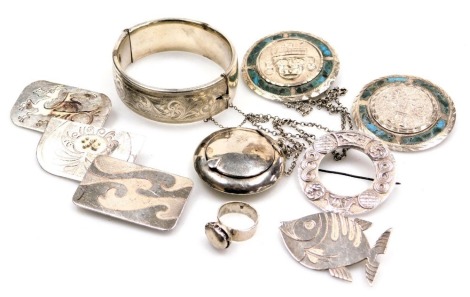 A silver bangle with foliate engraved decoration, on a snap clasp, a Celtic circular brooch, two Aztec circular brooches, further brooches, a ring, and a silver powder box on chain.