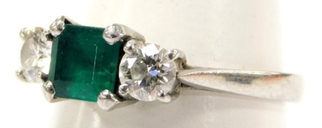 A platinum emerald and diamond three stone ring, the square cut emerald approximately 0.7 carats, diamonds approximately 0.8 carats, size P, 5.2g.