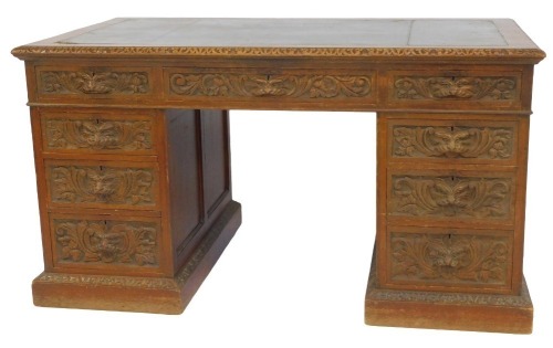 A Victorian carved oak twin pedestal desk, with leather top and carved mask head handles, 180cm x 82cm.