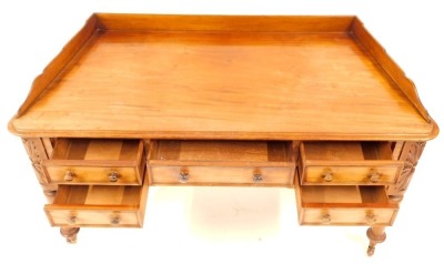 A Victorian mahogany dressing table, with canted sides, having shaped low gallery back and with thumb moulded border, fitted central drawer, above a knee hole flanked by two shallow drawers to each side, with carved foliate decoration to the corners above - 2