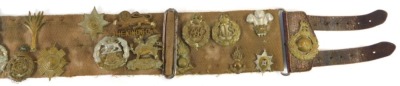 A canvas and leather belt containing various cap badges, to include Hampshire Regiment, Prince Albert's Own South Africa 1900-2, York and Lancaster Regiment, Dorsetshire Regiment, etc. together with a leather belt with buckle. - 4