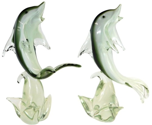 A pair of Murano glass dolphins, each on a grey, black and white ground, riding a wave, 38cm high.