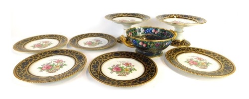 A late 19thC Booths china part service, comprising five dinner plates and two centrepiece bowls, each with a dark blue and gilded border with transfer printed floral decorated to centre, and a Minton Rotique pattern fruits and flowers bowl, on a blue and