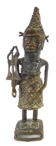 A 20thC Nigerian Benin cast bronze figure, carrying tribal sword, on a square base, 38cm high.