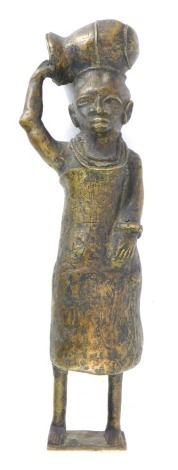 A late 20thC Nigerian Benin cast bronze figure, of a woman carrying water jug, on a rectangular base, 48cm high.