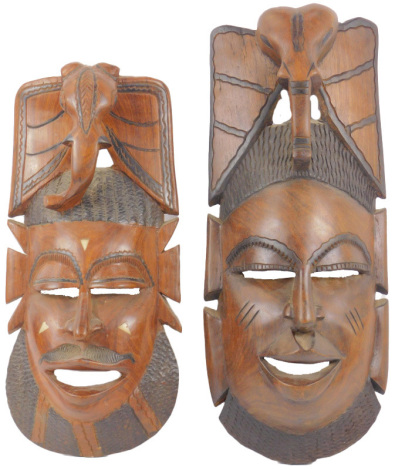 Two tribal hardwood masks, each surmounted by an elephant head, possibly Gambian, 52cm high and 44cm high.