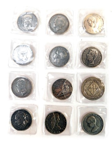 Nine replica Spanish five Pesetas coins for Alfonso XIII, dated 1888, 1892, 1899, 1891,1895 (x2), 1870, 1871 (x2), together with a five Pesetas coin for Alfonso XII dated 1881, a Ferdin VII coin for 1821, and a Barcelona five Pesetas coin dated 1814. (12)