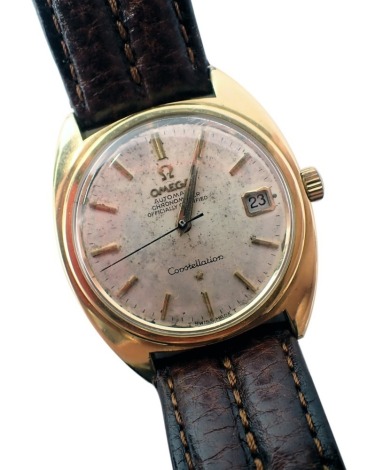 An Omega Constellation wristwatch, with a silvered dial and date aperture, with automatic movement, in a gold coloured outer case, on brown leather strap, the dial 3cm diameter.