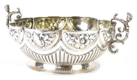 A Victorian silver rose bowl, with fluted and hammered floral design, with masked warrior scroll handles, on a reeded body on circular foot, stamped Thomas, 153 New Bond Street, maker F B Thomas & Co, London 1882, 12.83oz.