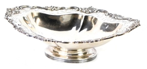 An Edward VII silver oval pedestal dish, with shell capped and reeded scroll border, on a pierced rim and stepped foot, maker Thomas Latham & Ernest Morton, Chester 1906, 13.15oz.